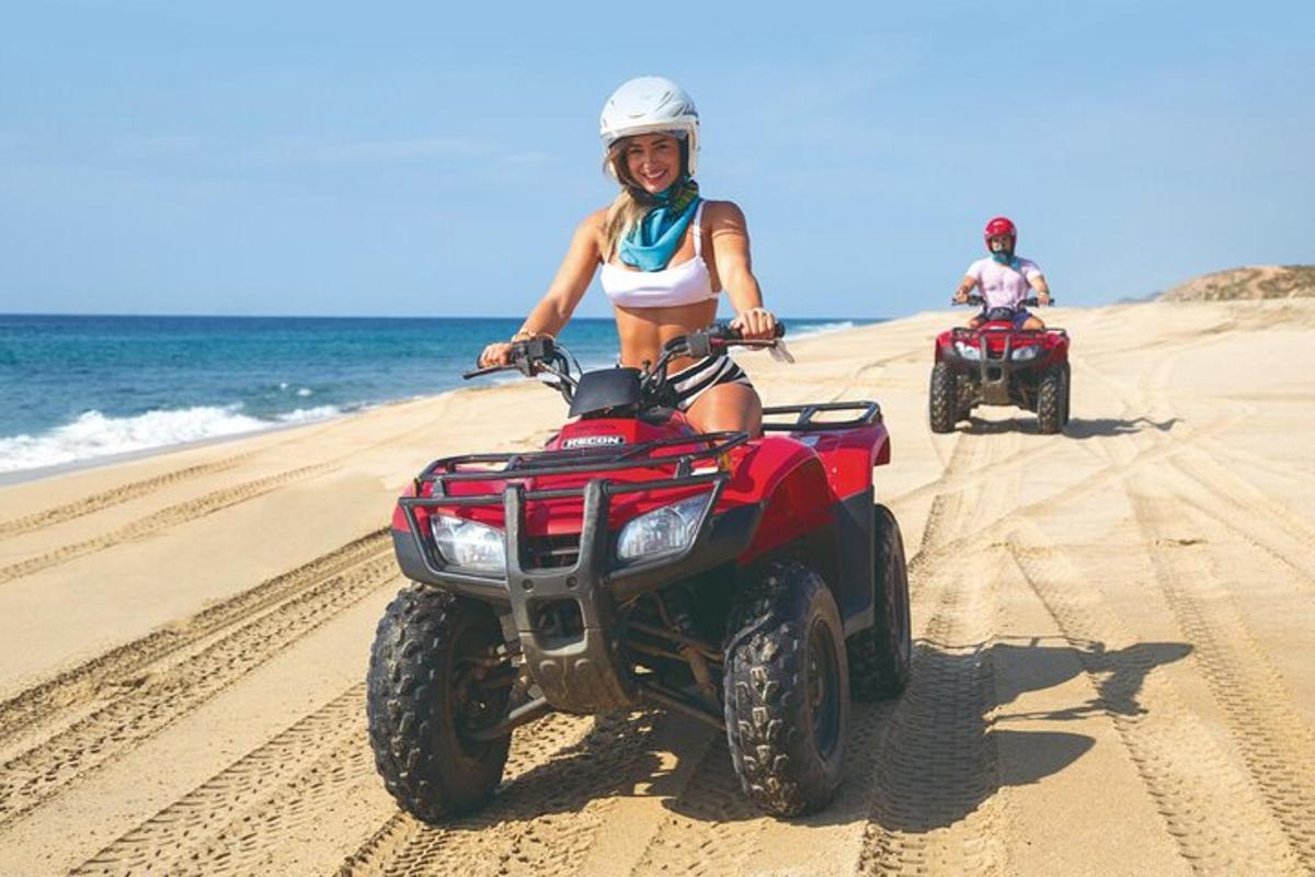 due persone in sella a un quad sulla spiaggia