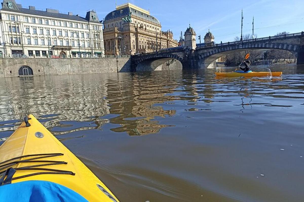 una persona in kayak in acqua vicino a un ponte