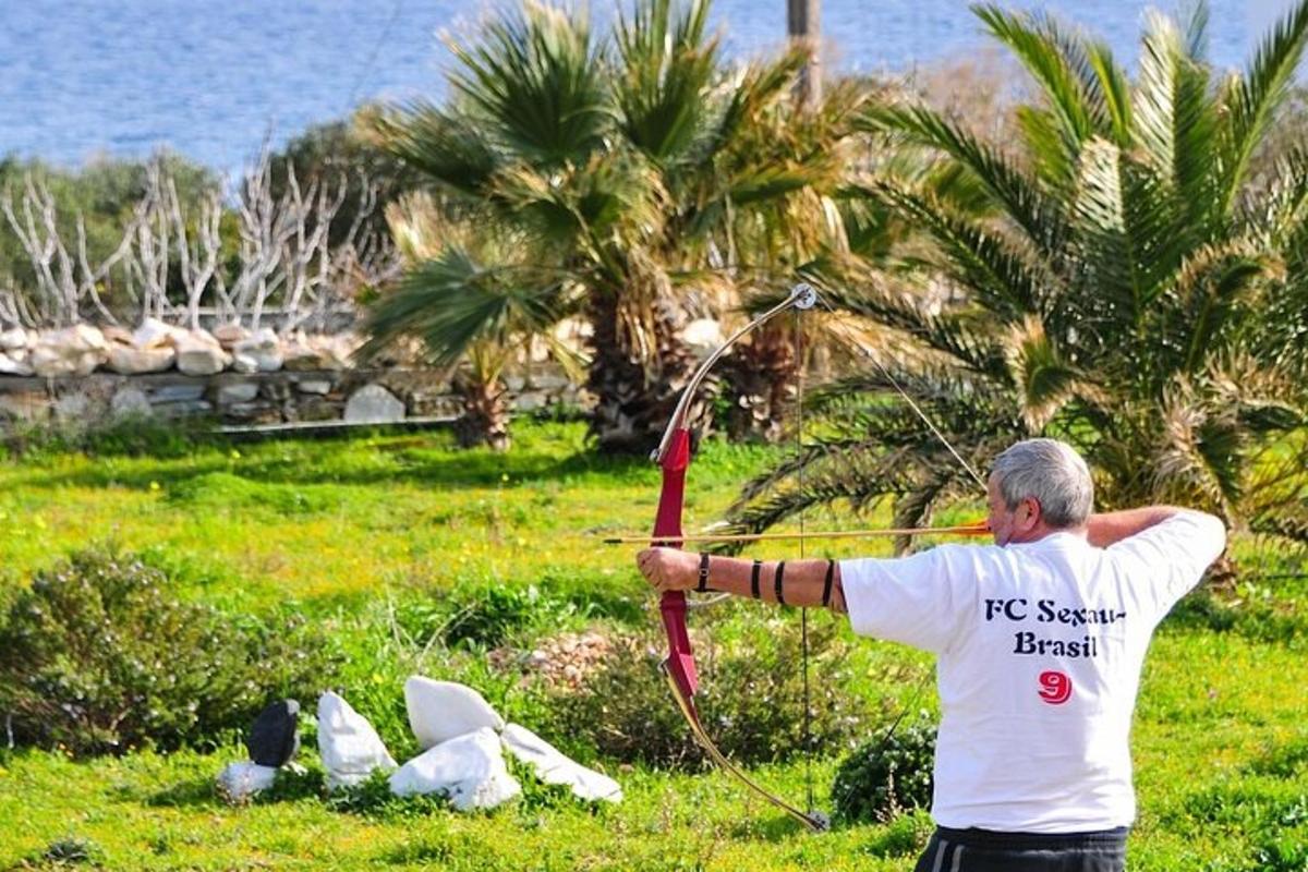 a man holding a bow and arrow in a field