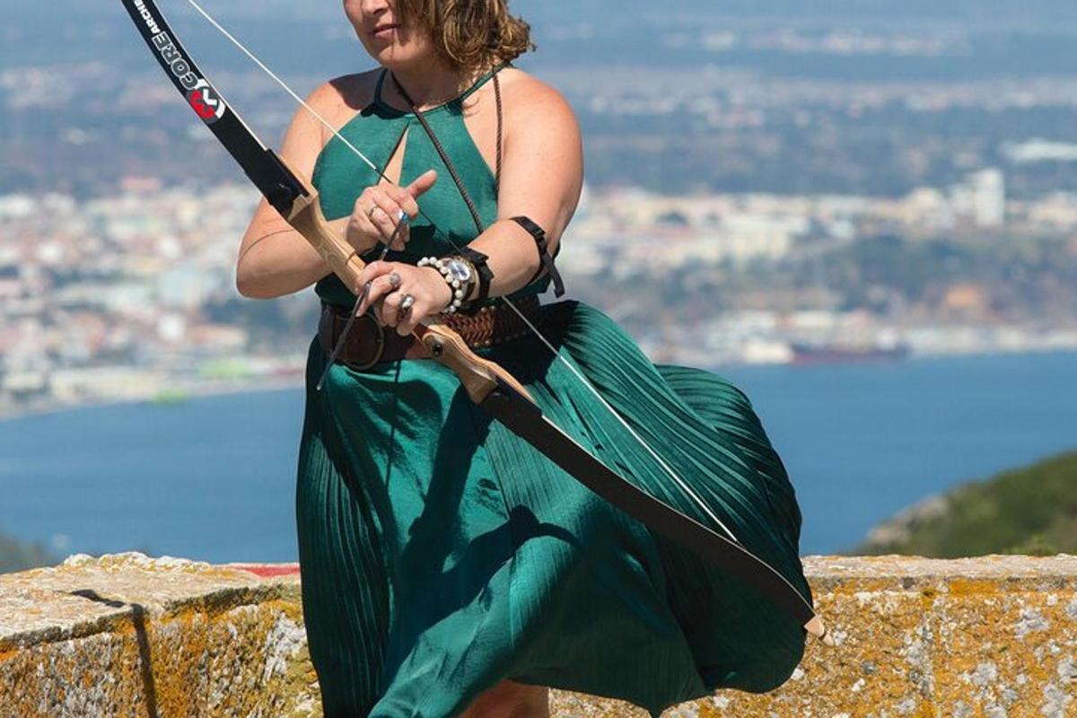 a woman in a green dress holding a bow and arrow