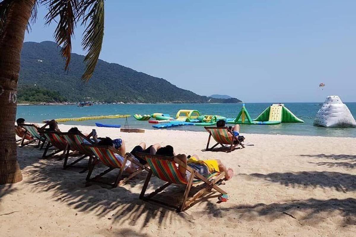 skupina ljudi, ki ležijo na vrtnih stolih na plaži