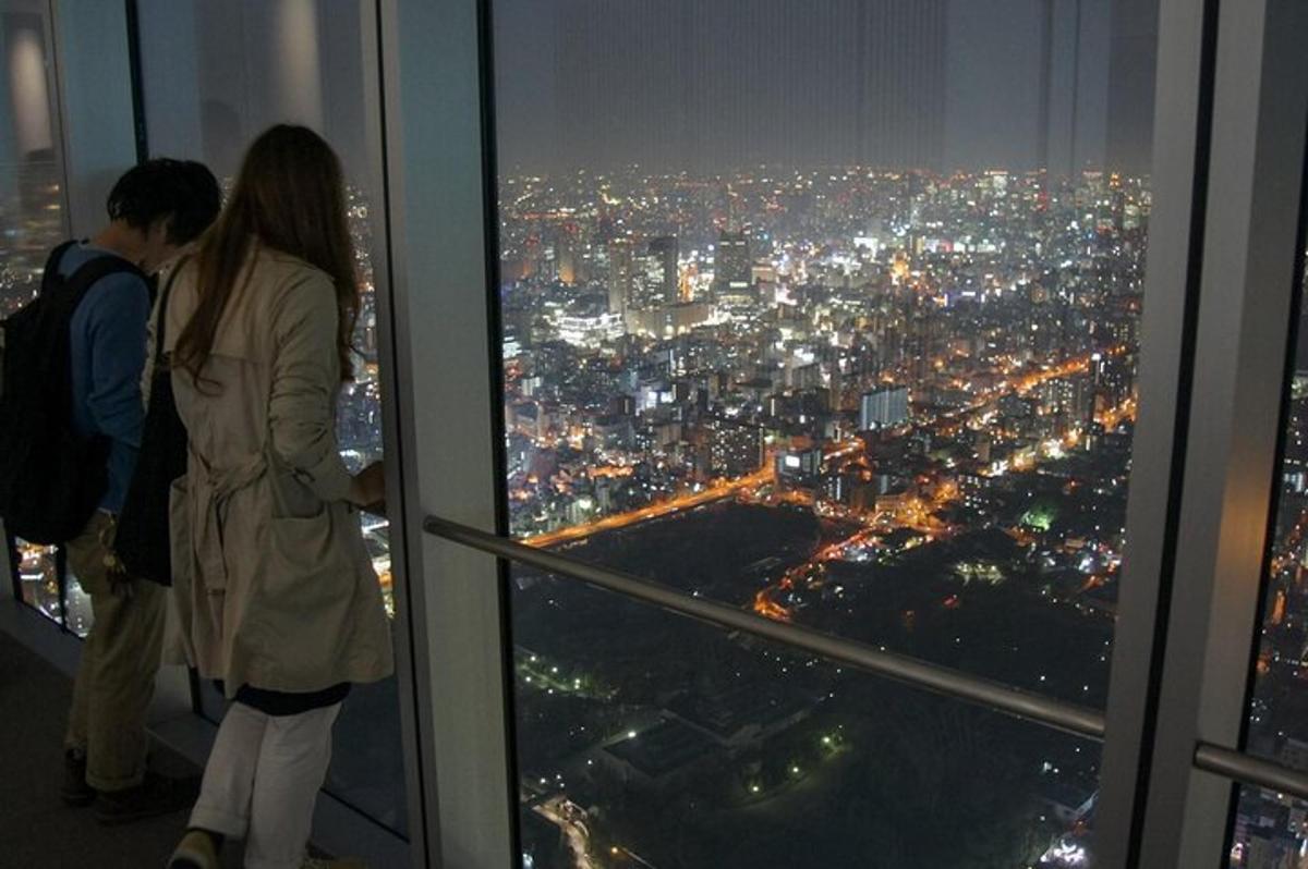 a couple looking out the window of a skyscraper