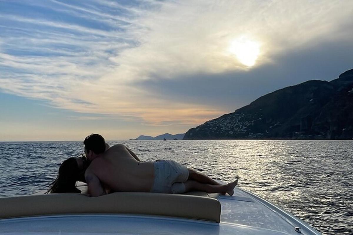 un uomo e una donna sdraiati su una barca in acqua