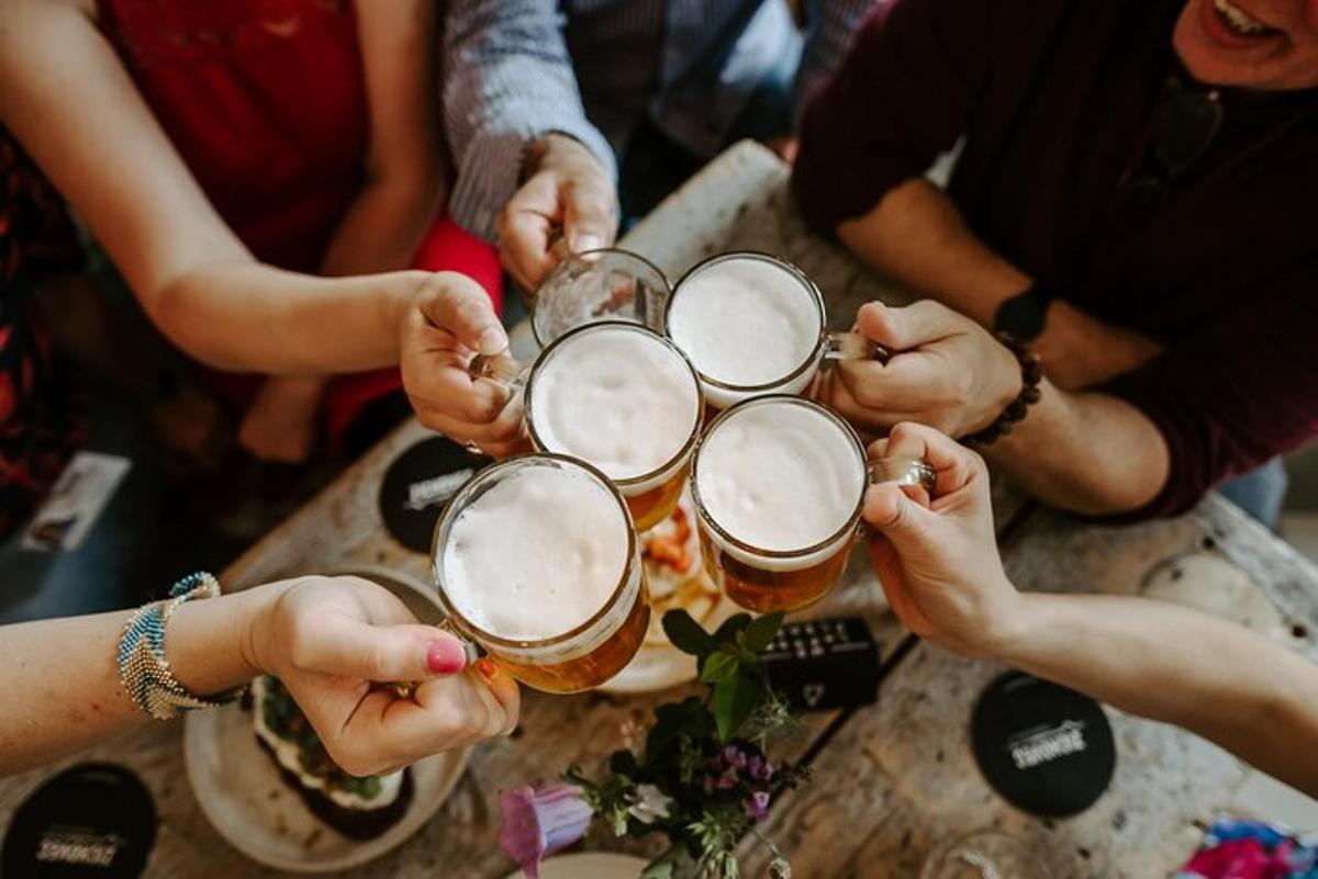 um grupo de pessoas sentadas ao redor de uma mesa bebendo cerveja