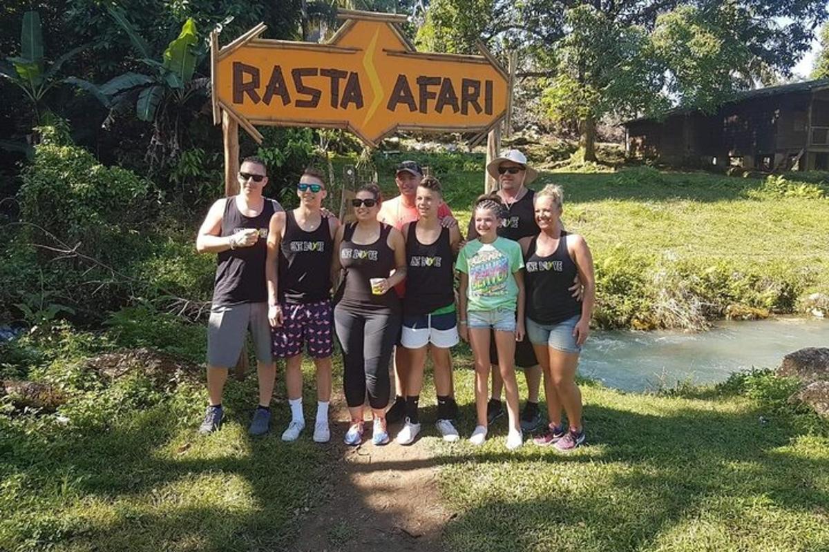een groep mensen die poseren voor een foto onder een bord
