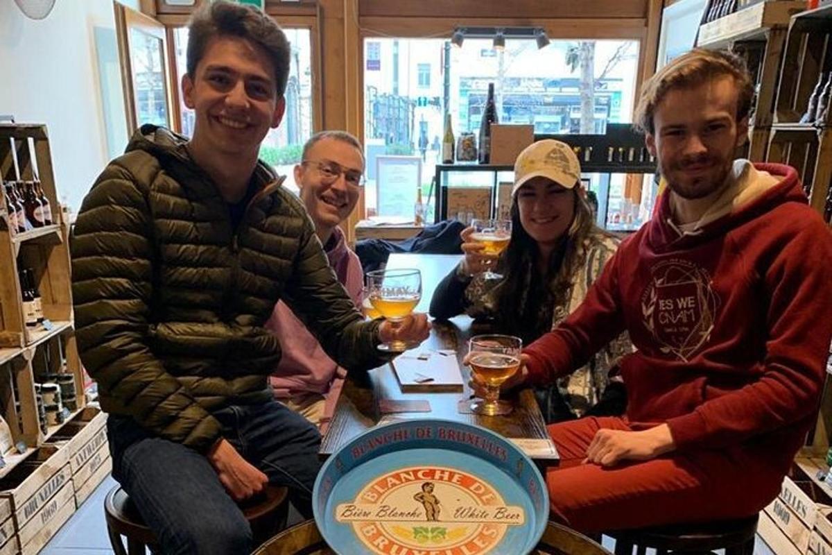 un grup de persones assegudes al voltant d'una taula amb begudes