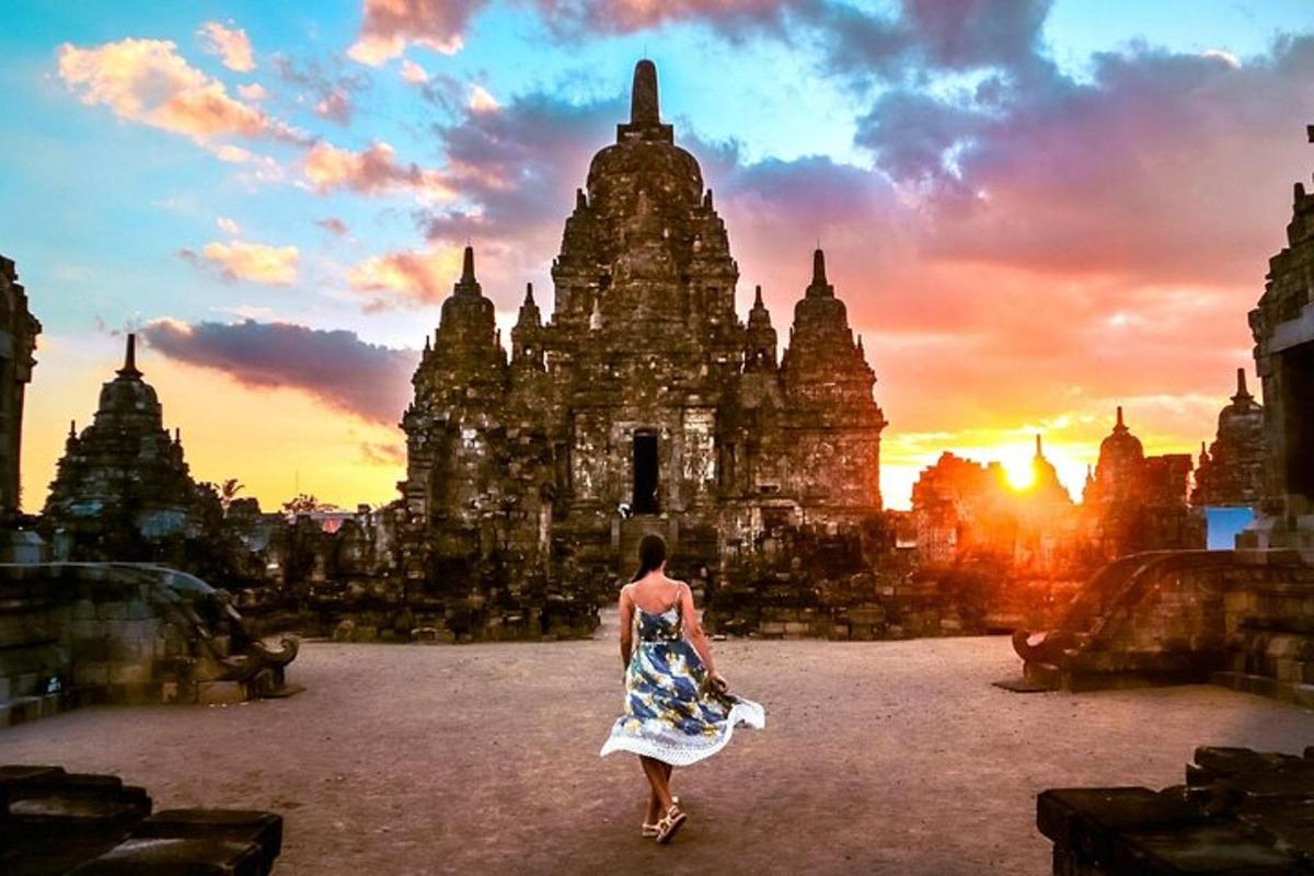uma mulher caminhando em frente a um prédio com o pôr do sol