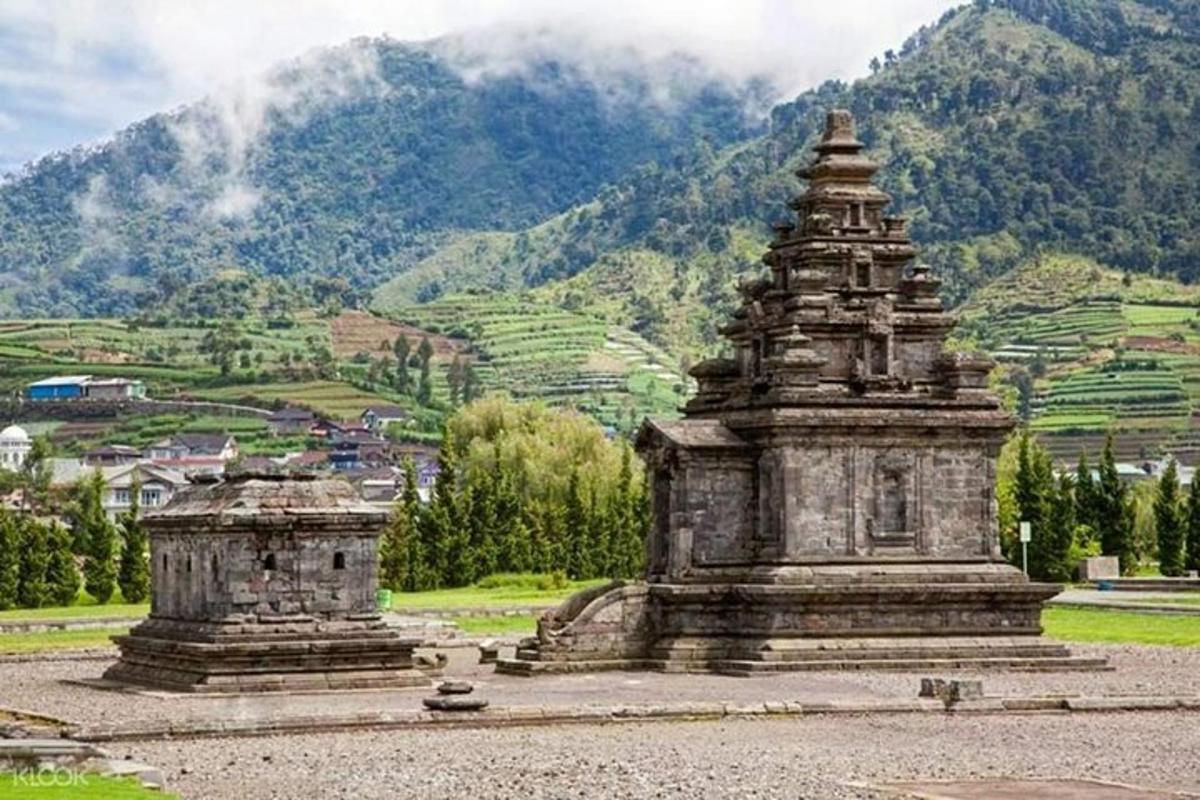 sebuah monumen batu besar di hadapan gunung