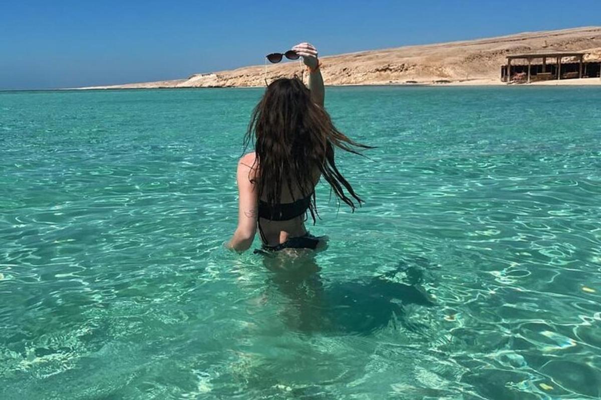 uma mulher está parada na água com uma garrafa