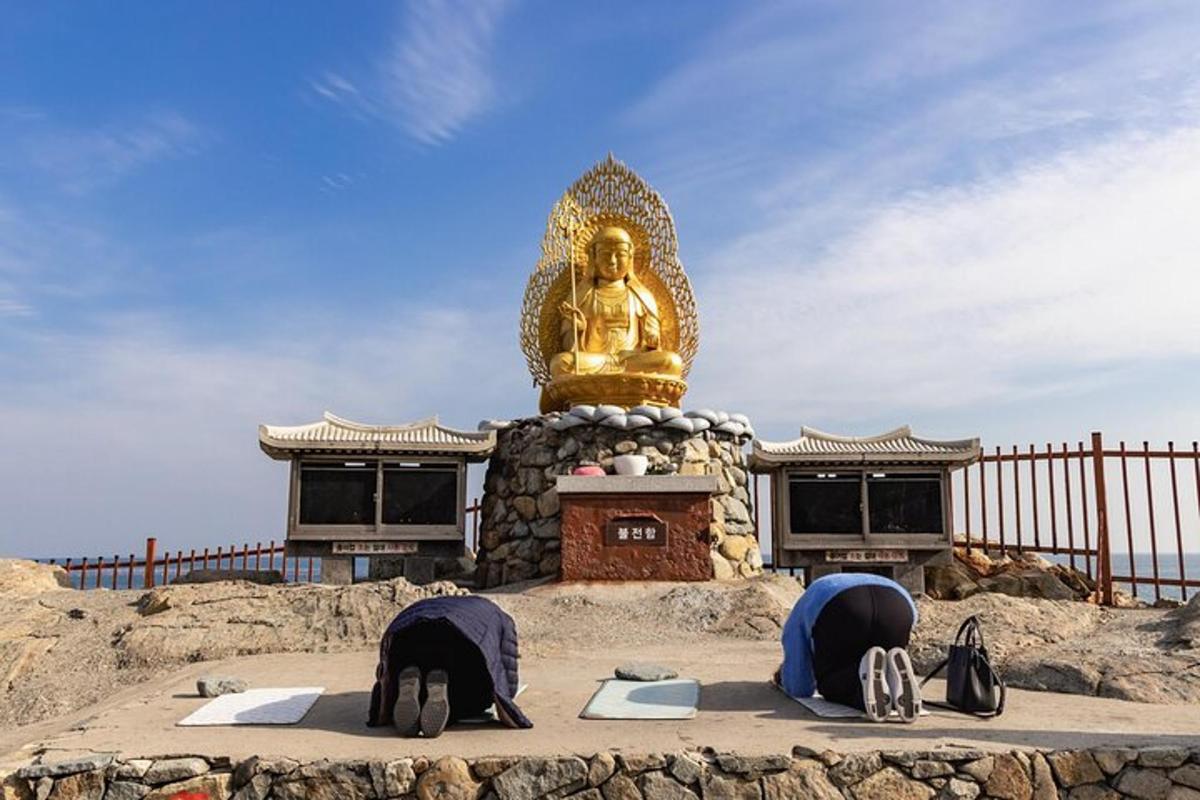 two people sleeping in front of a buddha statue