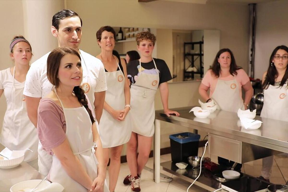 a group of people wearing aprons in a kitchen