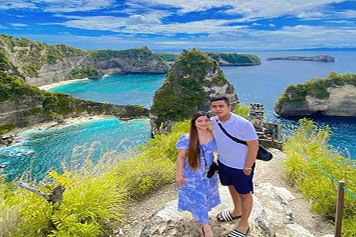 a man and a woman standing on top of a mountain