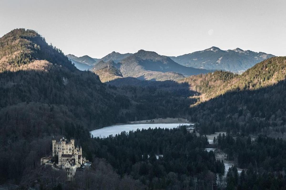 un castell al mig d'una muntanya amb un llac