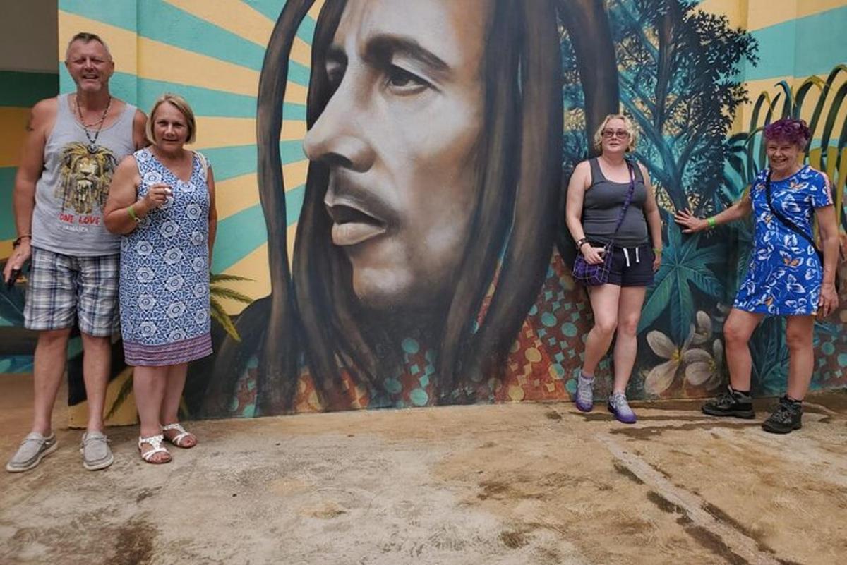 Un grupo de personas de pie frente a un mural.