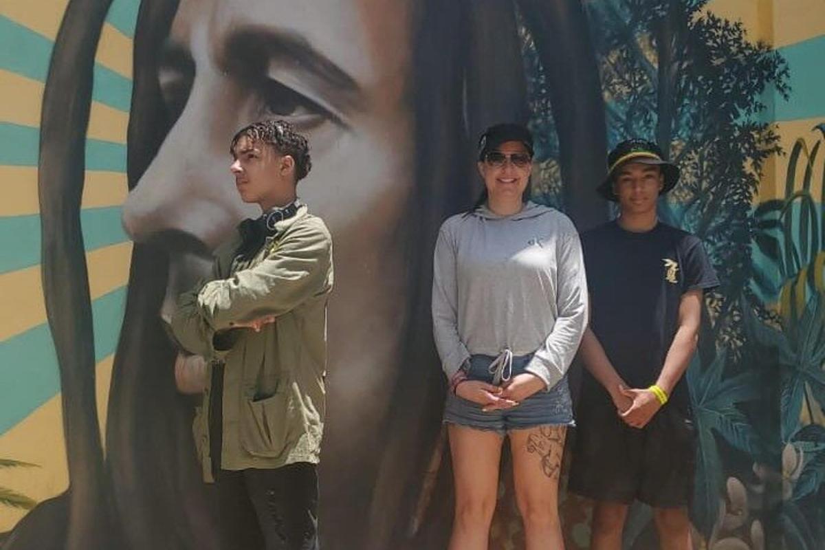 tres homes drets davant d'una pintura d'una dona