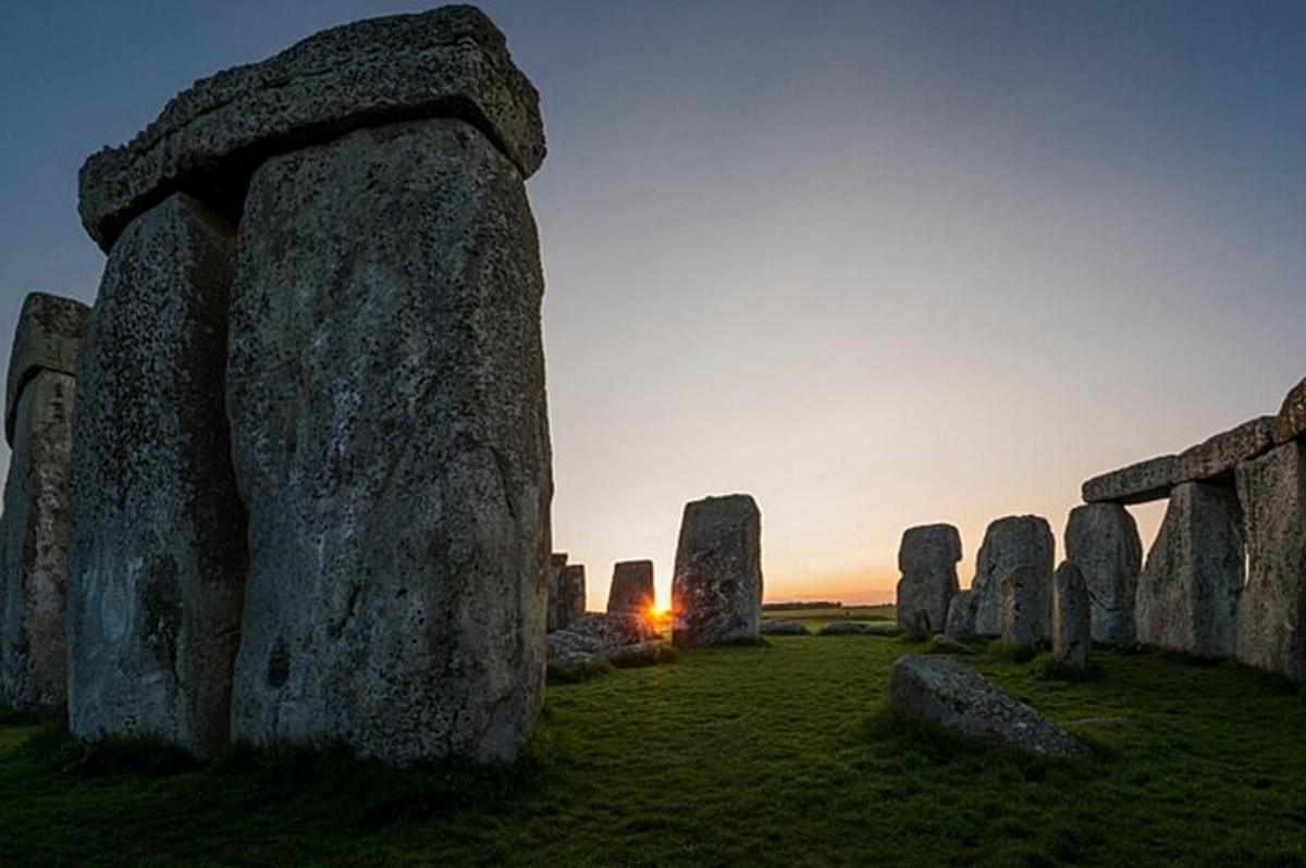 eine Gruppe großer Felsen auf einem Feld mit Sonnenuntergang