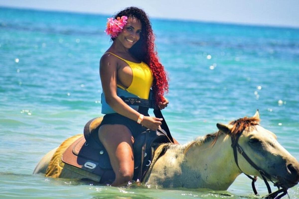 una mujer montando a caballo en el océano