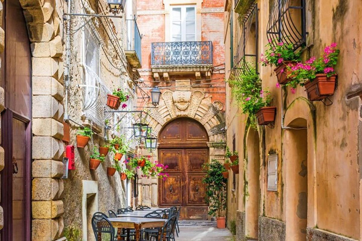 an alley with a wooden door and tables and chairs