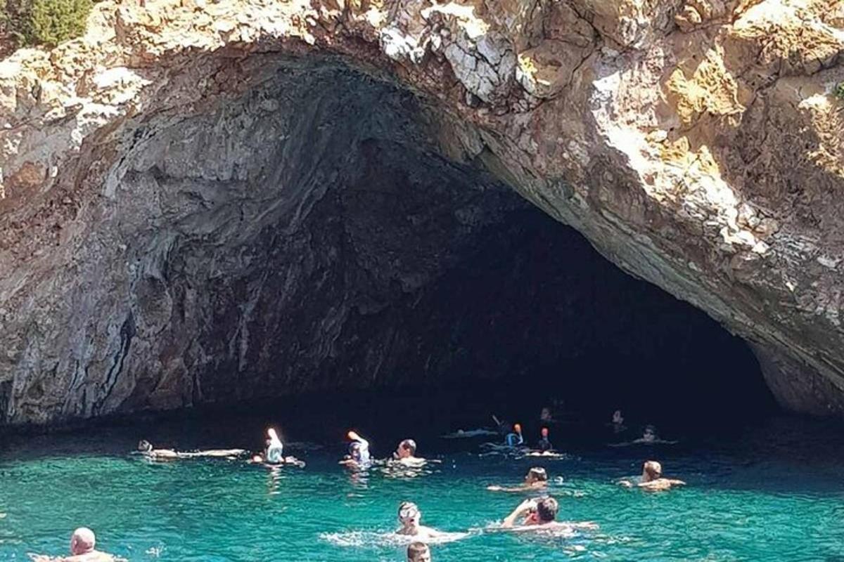 a group of people swimming in the water in a cave