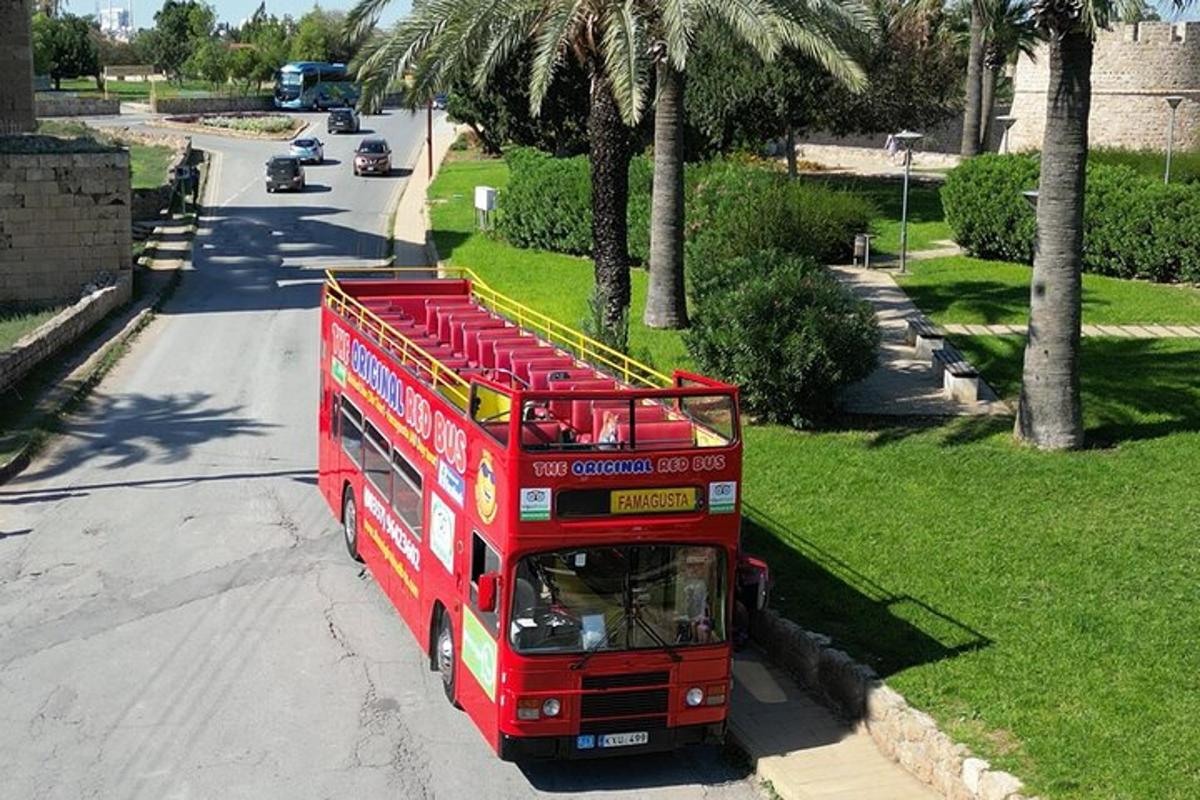 červený dvoupatrový autobus jedoucí po ulici