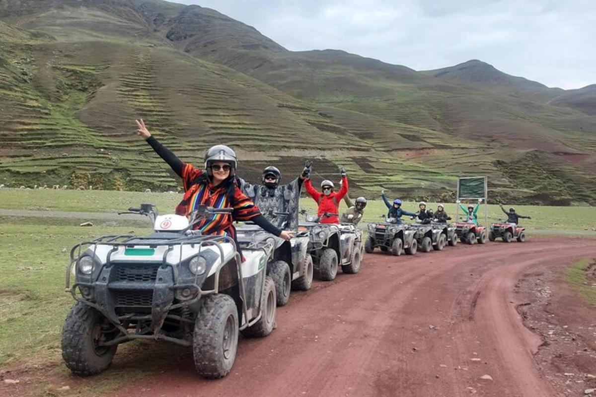 um grupo de pessoas andando de quadriciclo em uma estrada de terra
