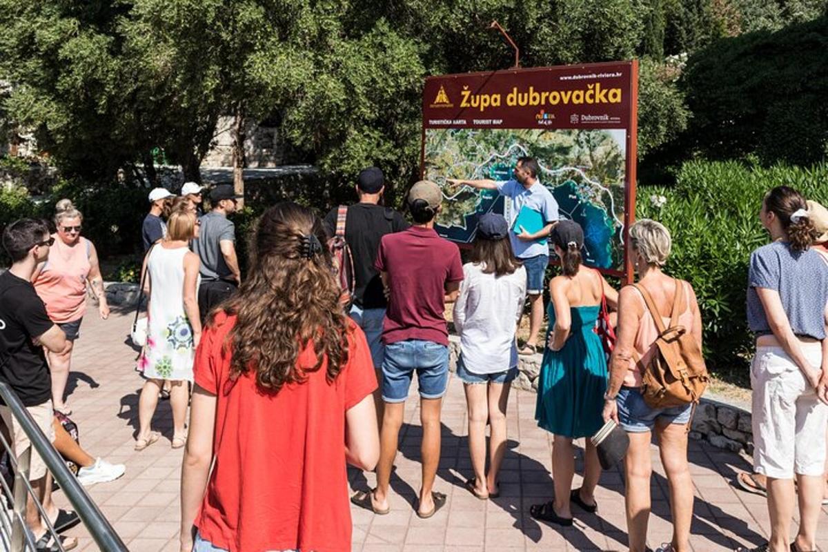 μια ομάδα ανθρώπων που στέκονται γύρω από μια πινακίδα