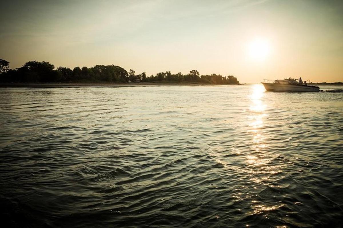 un vaixell en una massa d'aigua amb la posta de sol