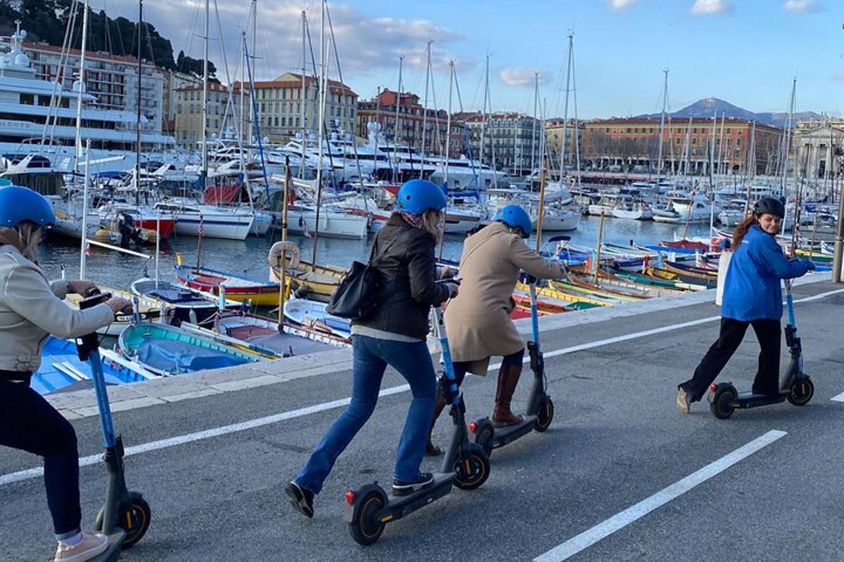 skupina ljudi, ki vozijo skuterje v bližini marine