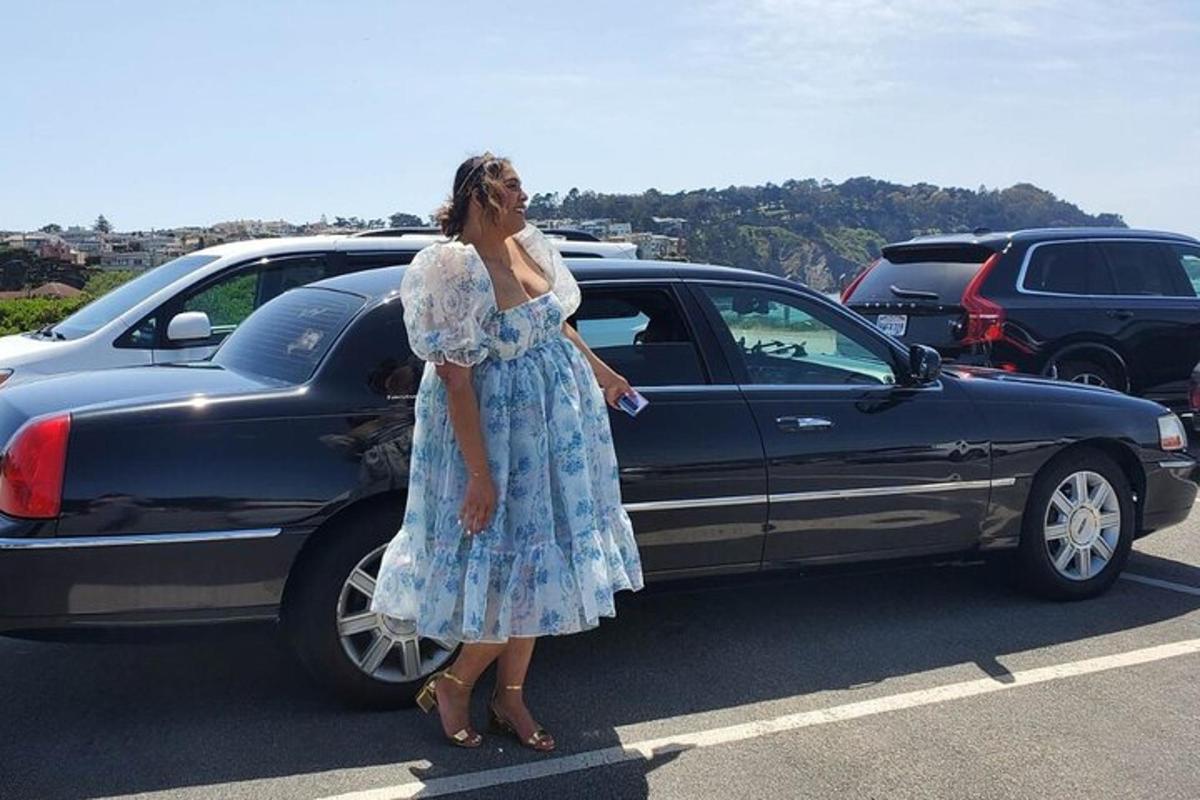 žena stojící vedle auta na parkovišti