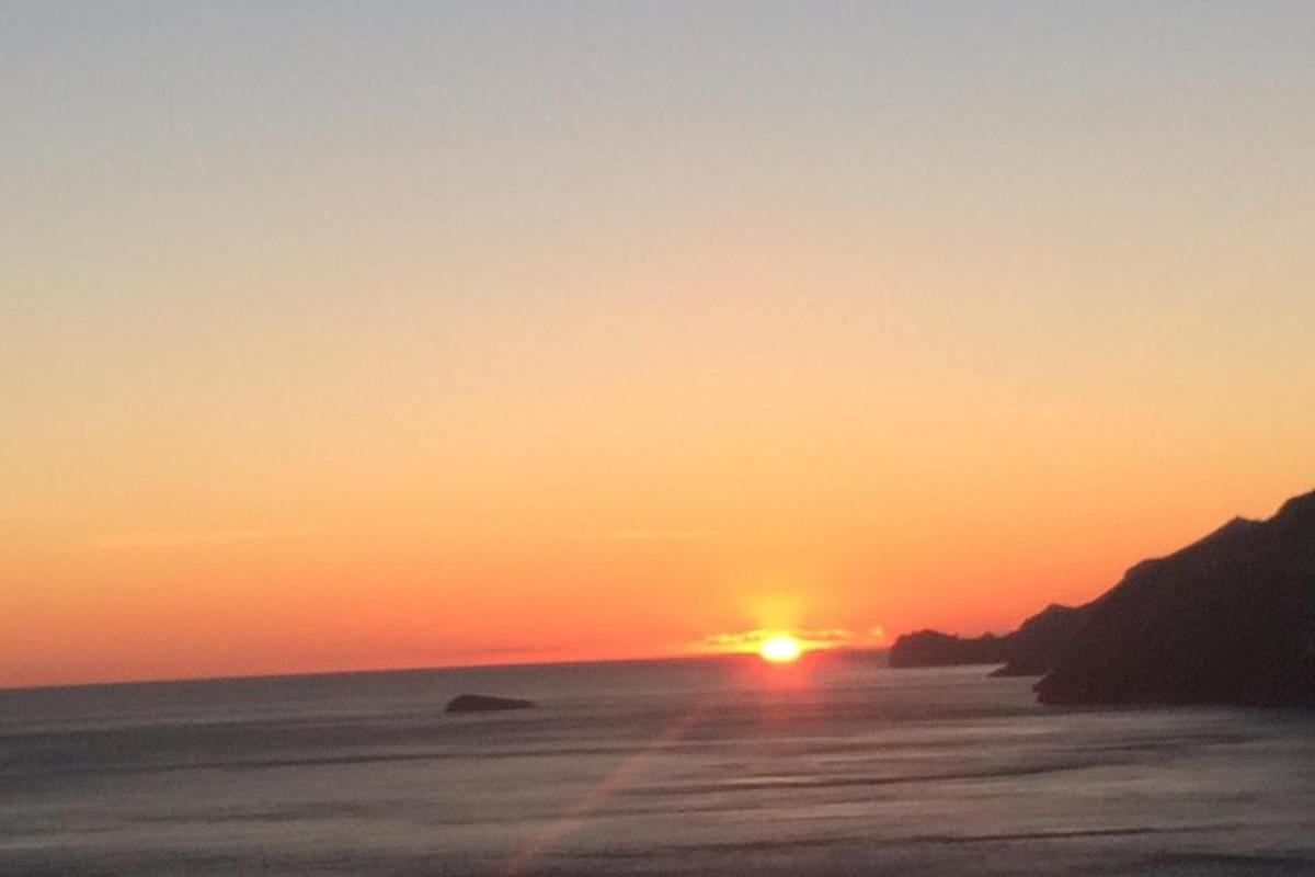 un tramonto sulla spiaggia con il sole che tramonta