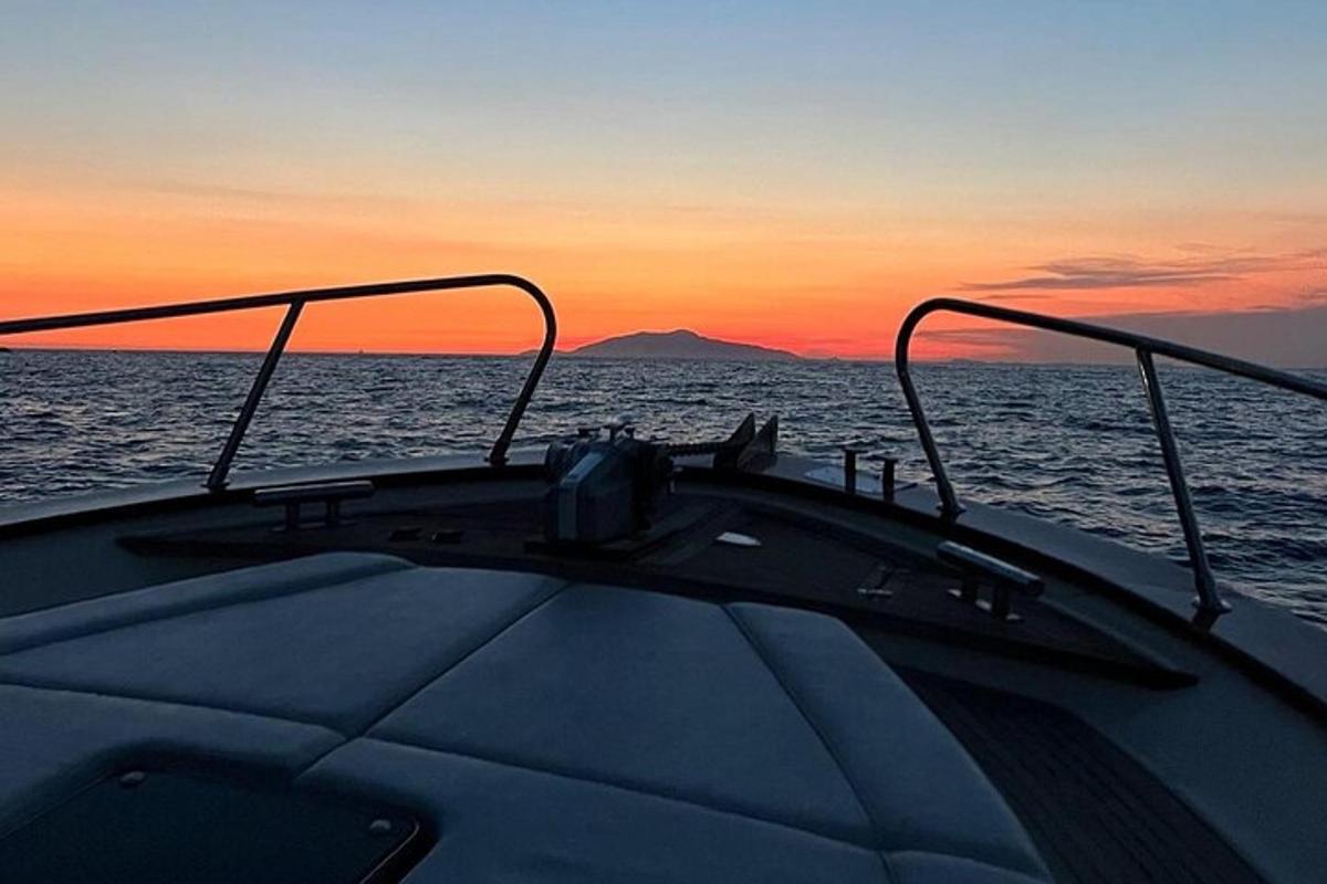 una barca nell'oceano con un tramonto sullo sfondo