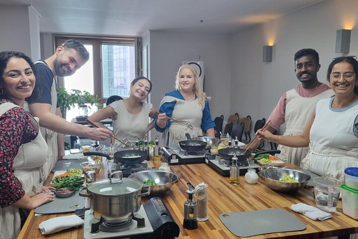 a group of people standing around a table preparing food