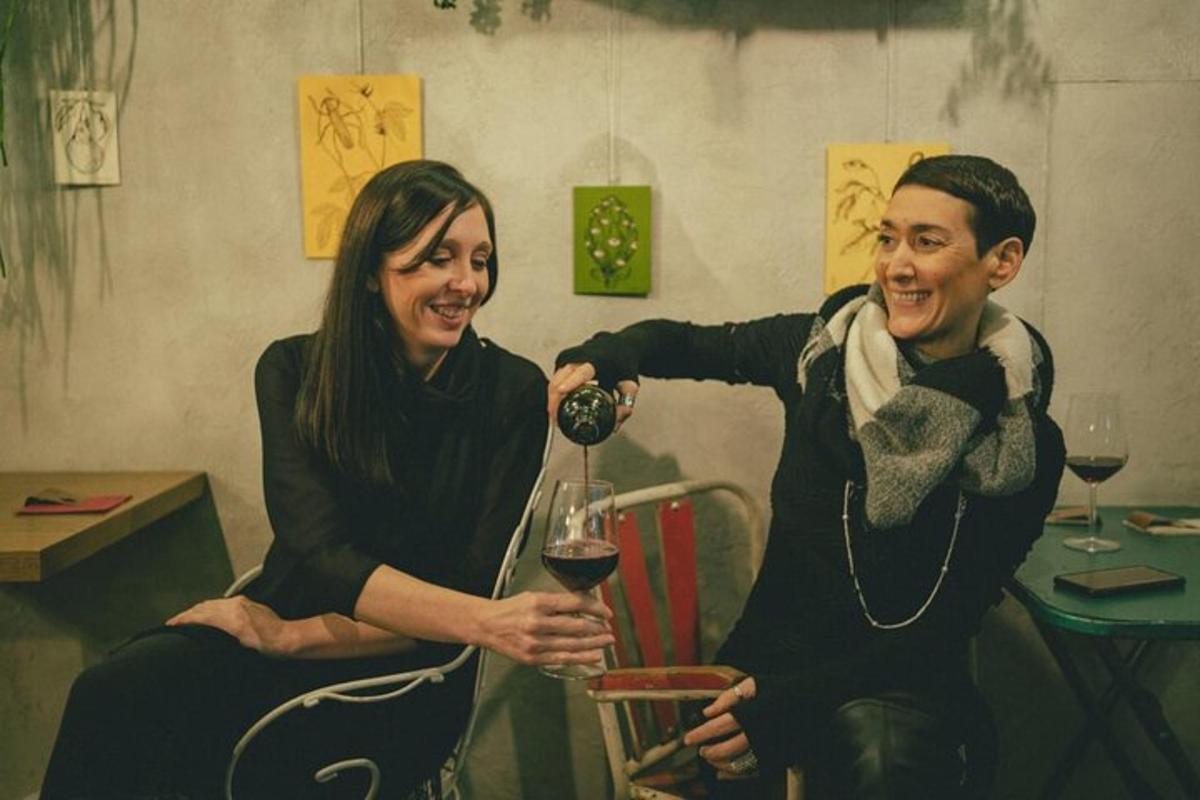 Una mujer sirviéndole una copa de vino a un hombre