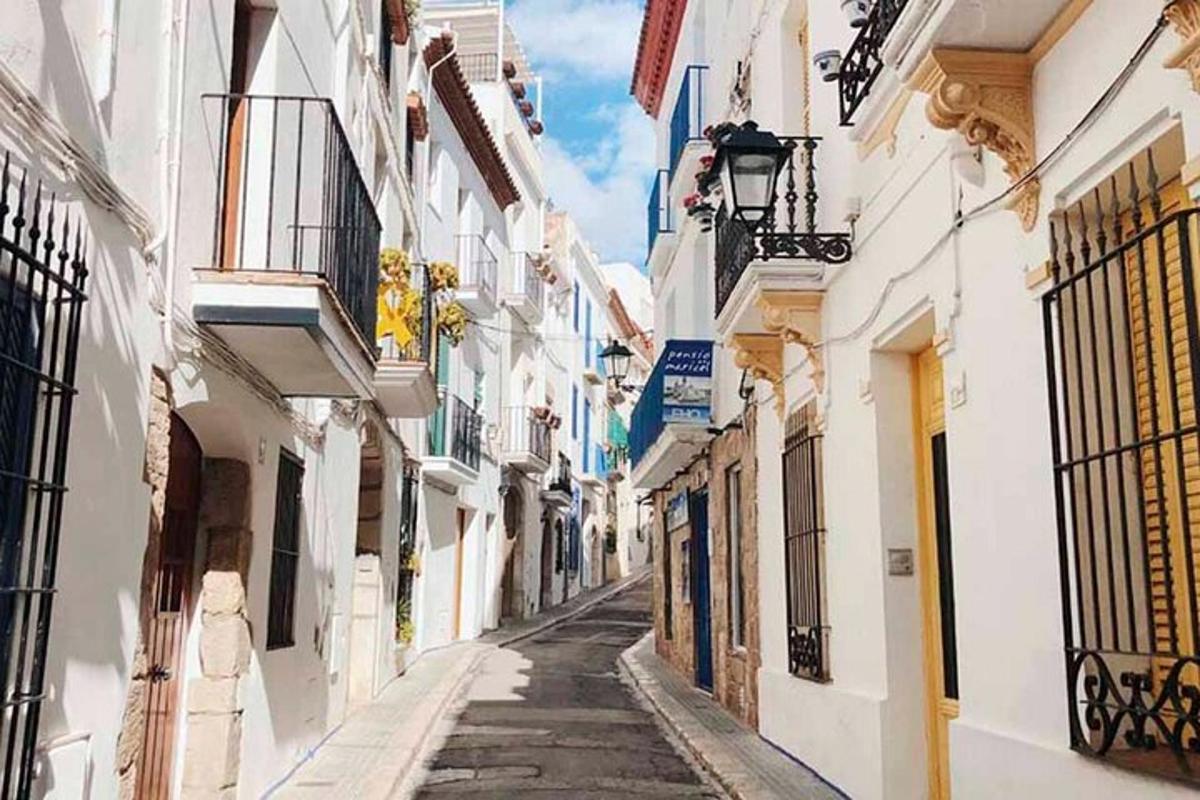 an alley in a city with white buildings