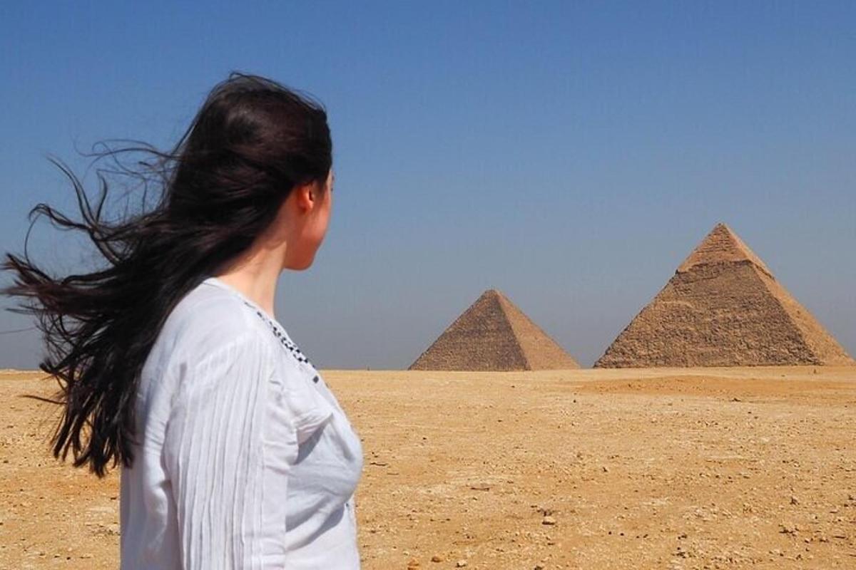 žena stojící před pyramidami