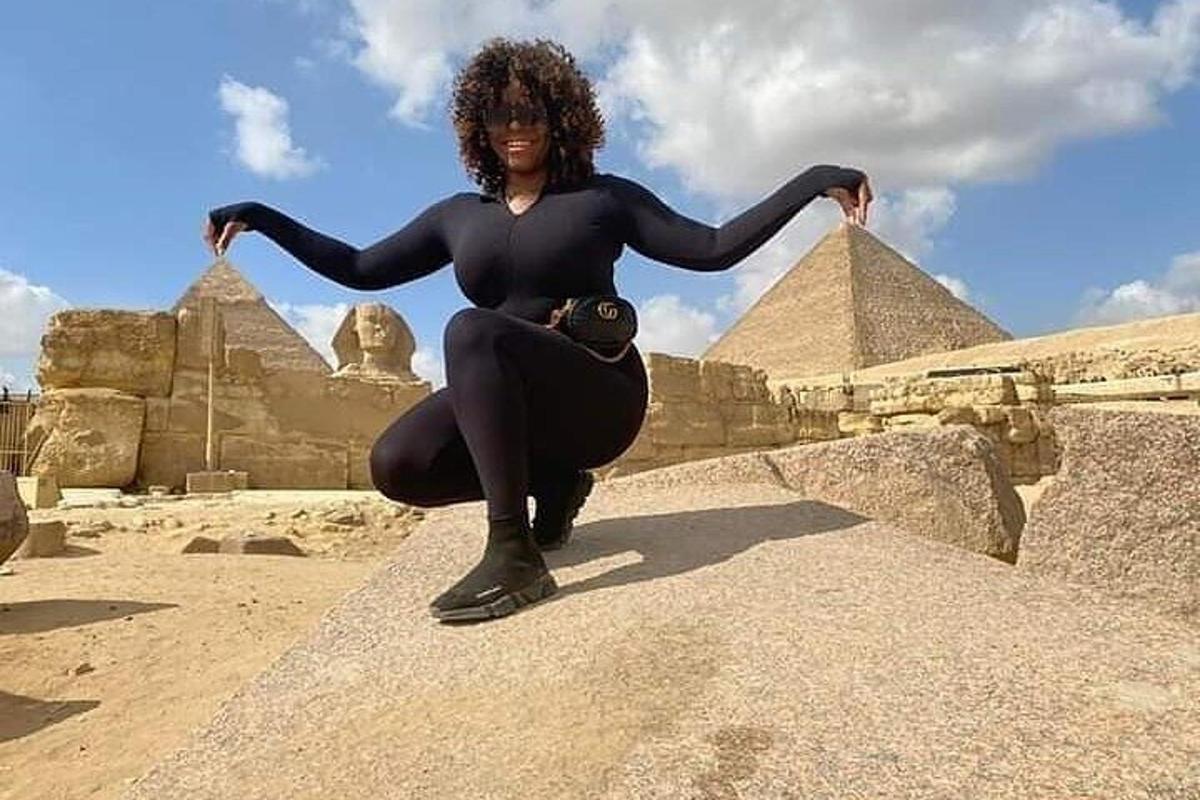 Žena pózuje před pyramidami