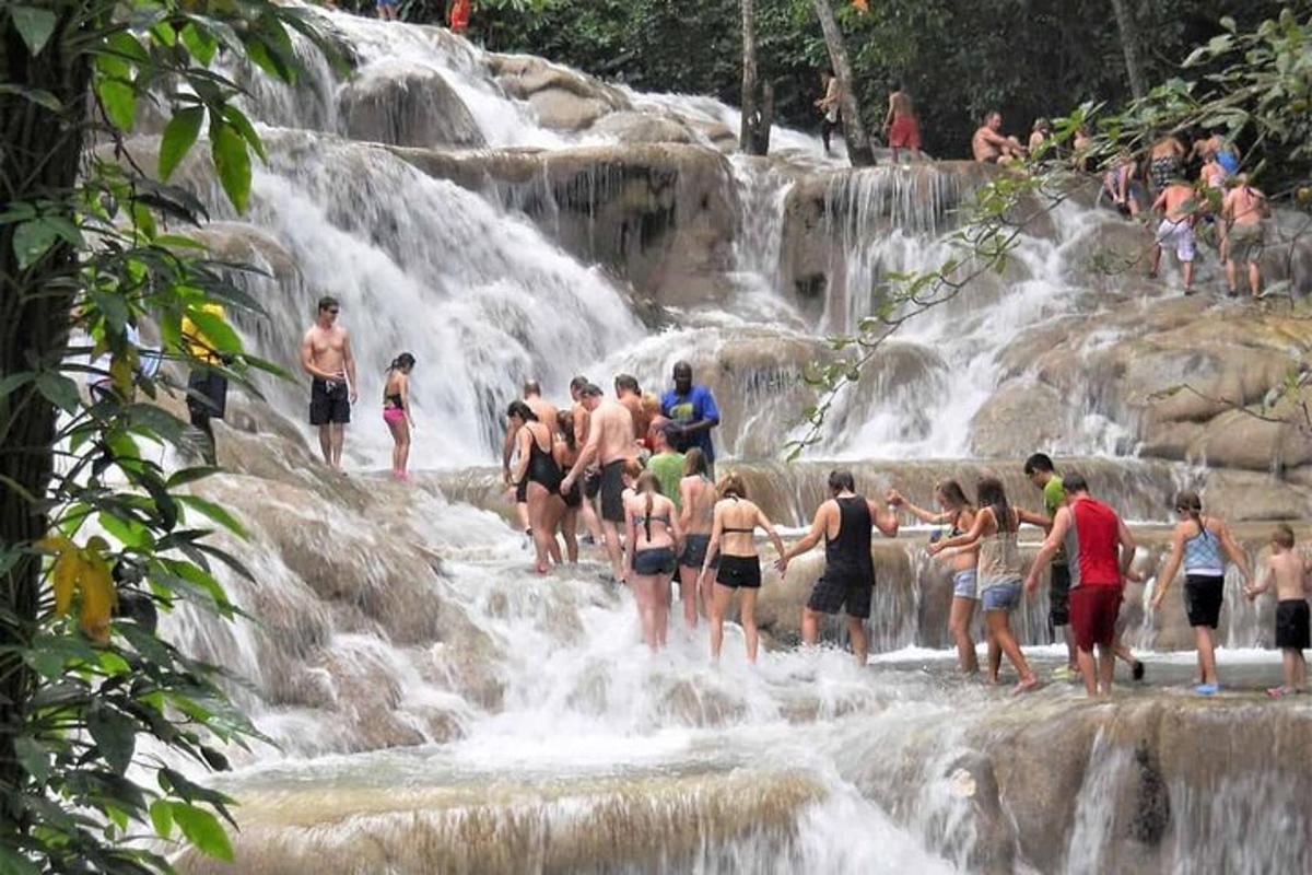 sekumpulan orang berdiri di dalam air terjun