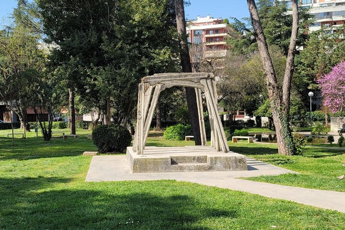 un arco di metallo in un parco con erba e alberi