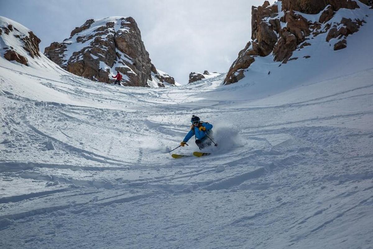 un uomo sta sciando giù da una montagna innevata