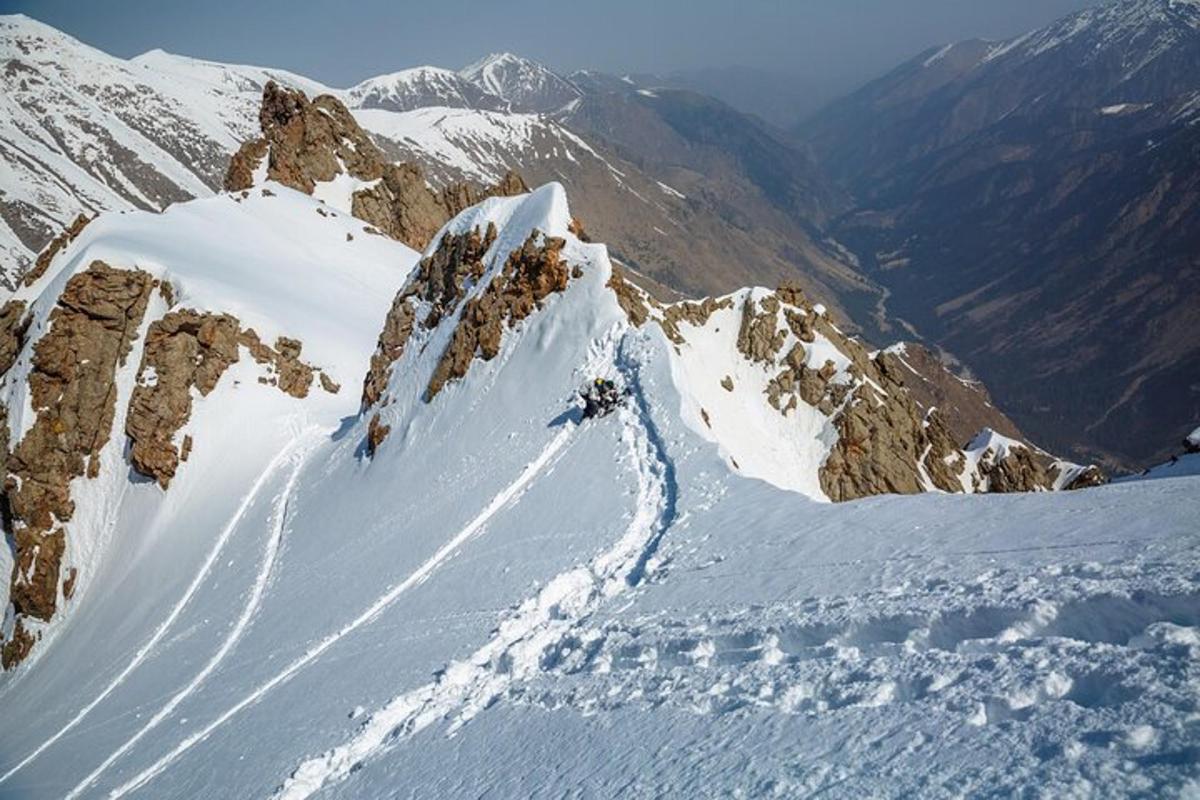 una persona sta sciando giù da una montagna innevata