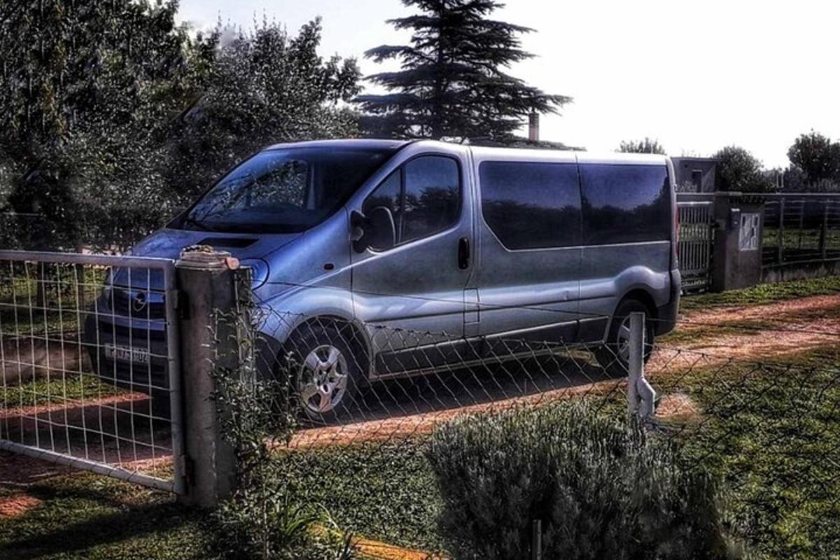 un furgone blu parcheggiato accanto a una recinzione