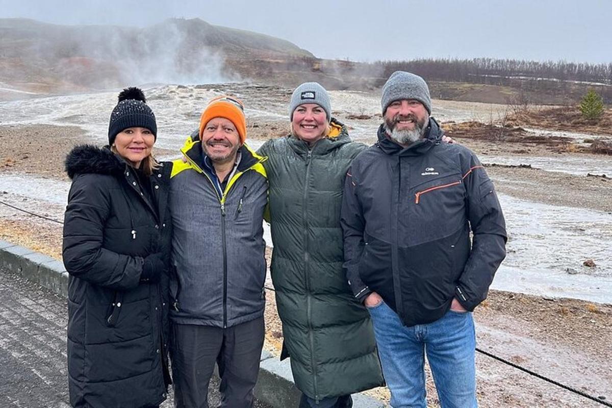 quattro persone posano per una foto davanti a un geyser