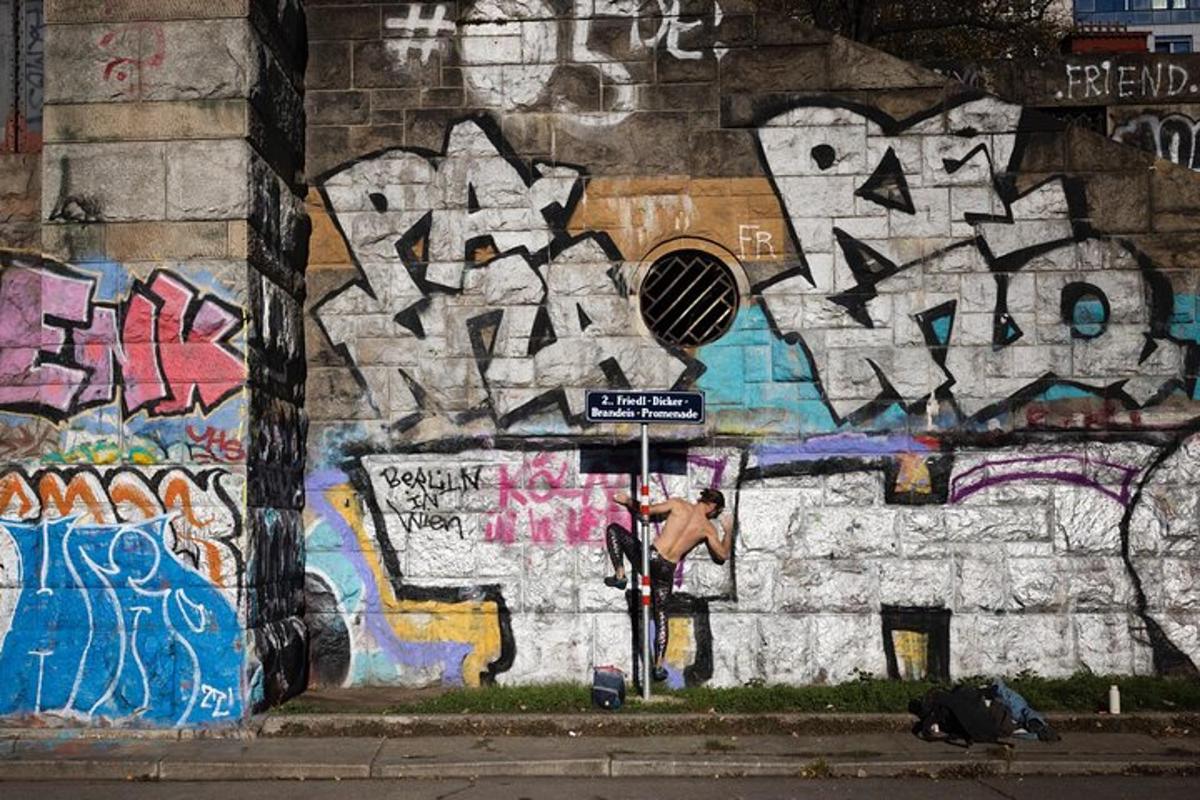 a wall covered in graffiti with a person standing in front