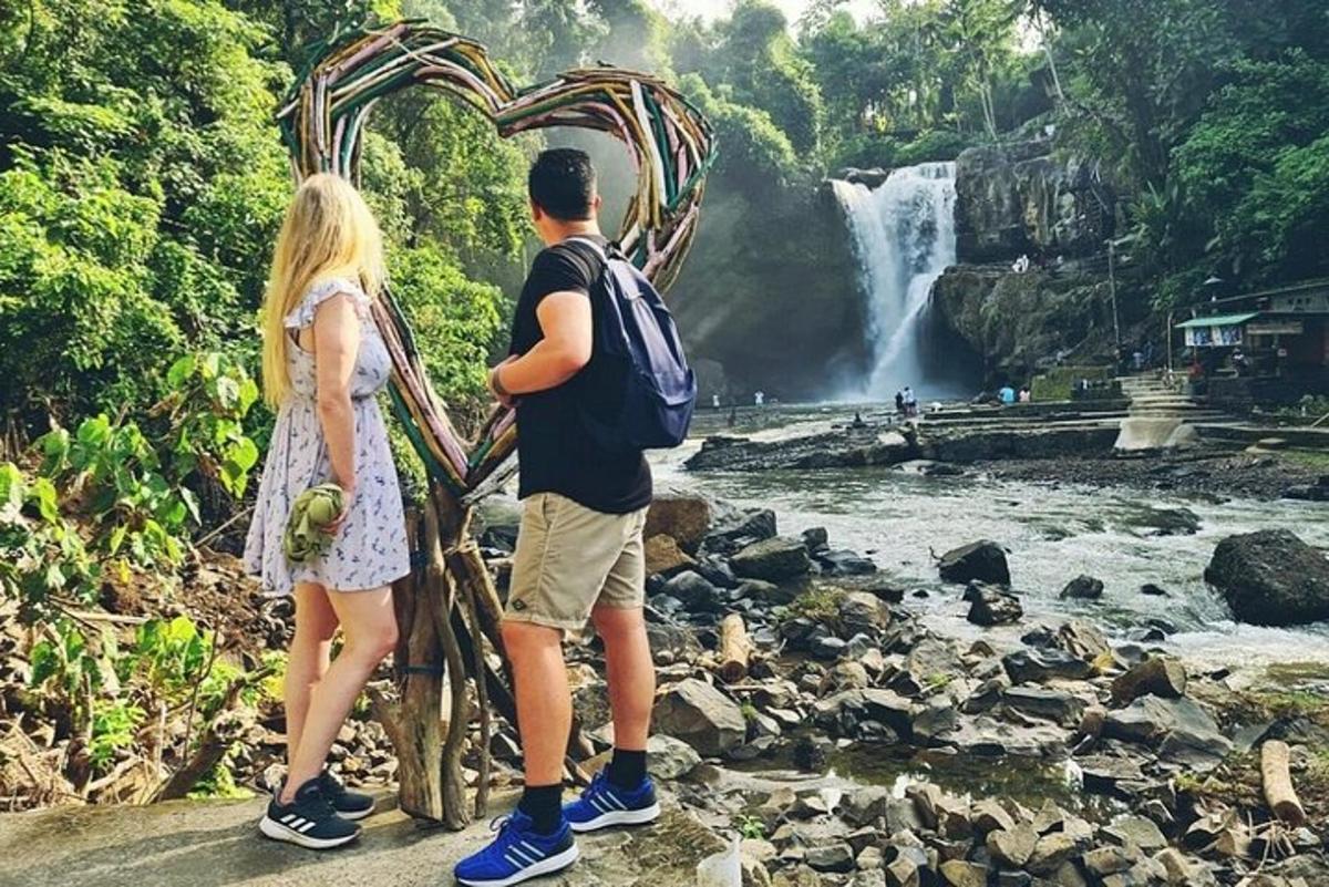 Maður og kona standa fyrir framan foss