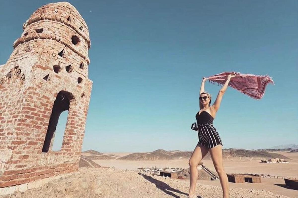 una mujer sosteniendo un paraguas en el desierto