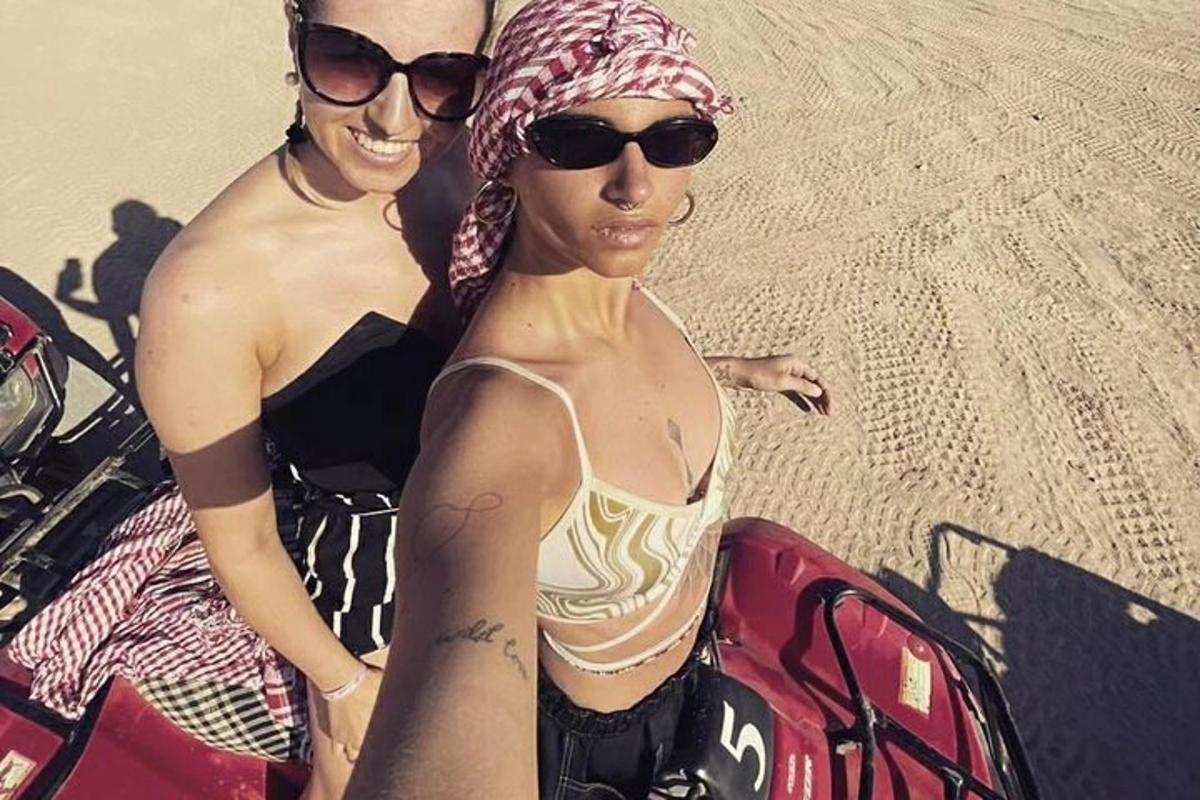 Dos mujeres en traje de baño de pie en la playa