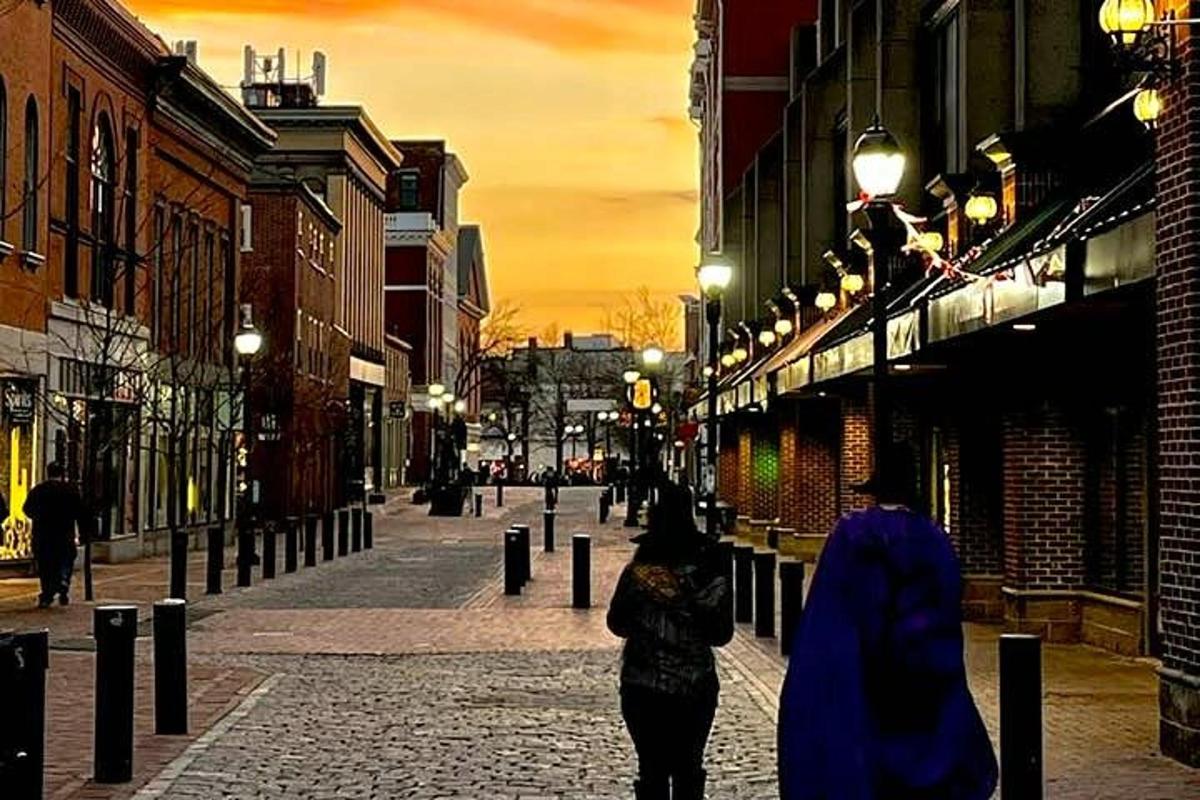a couple of people walking down a street at night
