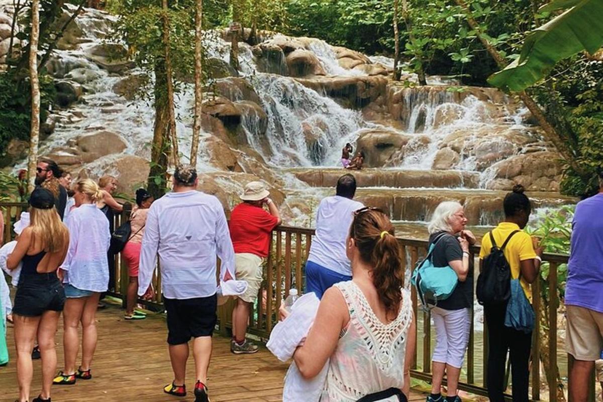 sekumpulan orang berdiri di hadapan air terjun