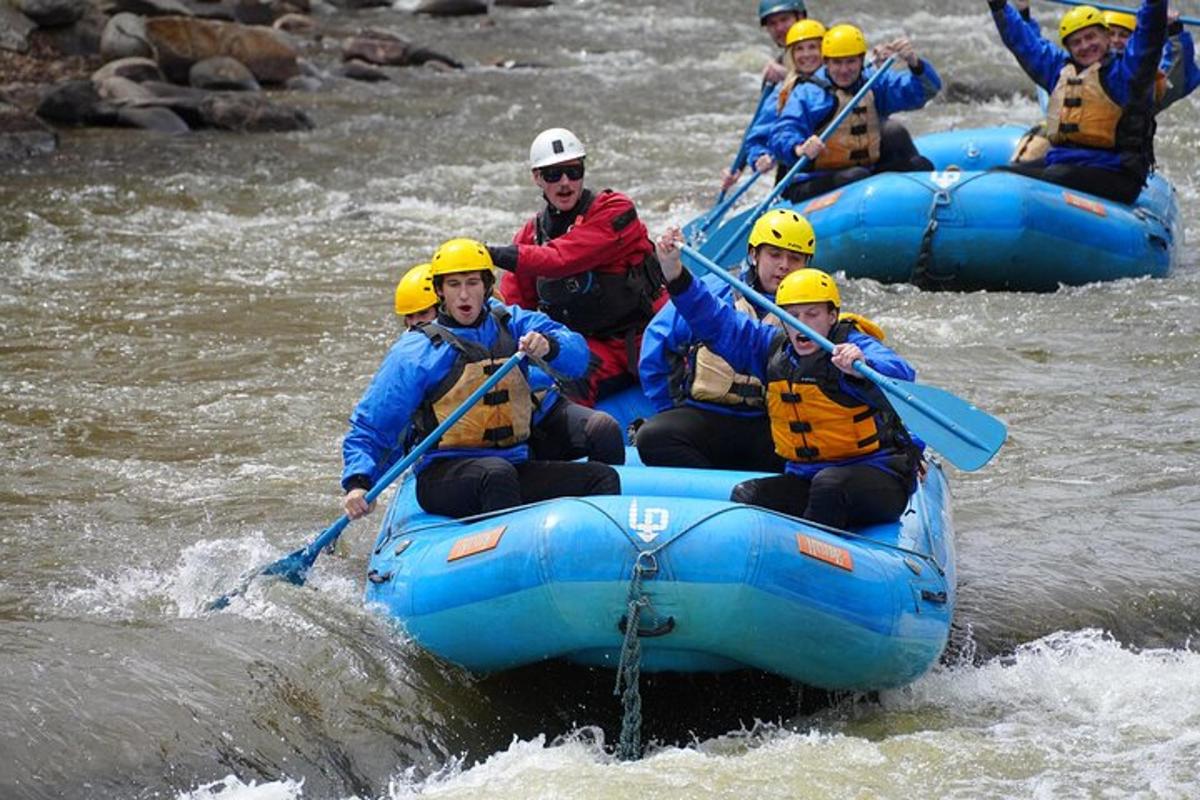 um grupo de pessoas descendo um rio de rafting