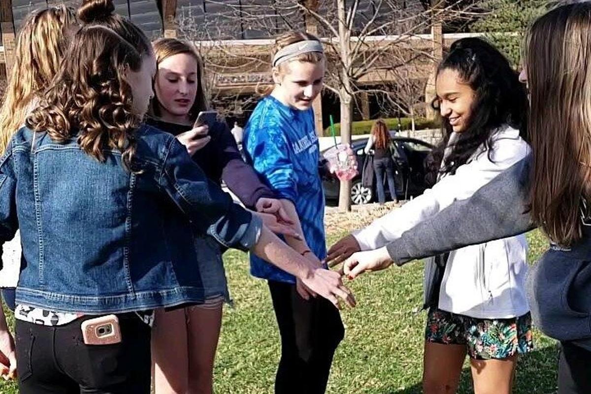 a group of young girls standing around each other